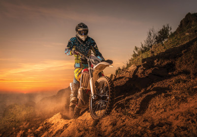 Papier peint mural représentant une moto de motocross au coucher du soleil pour le salon